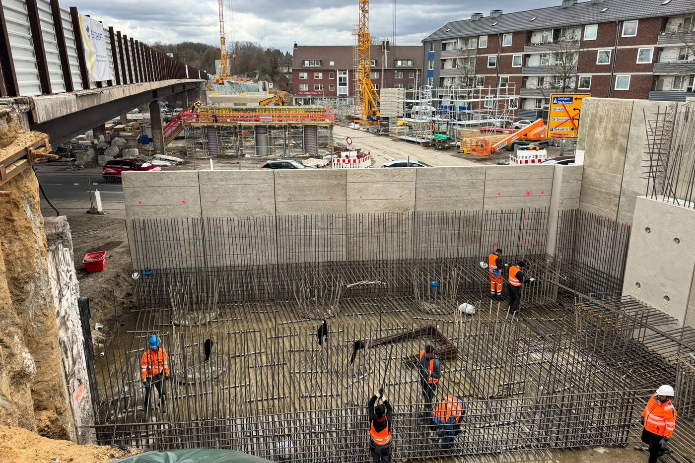 Baugrube unter der A516 in Oberhausen mit Kränen und Kolonne
